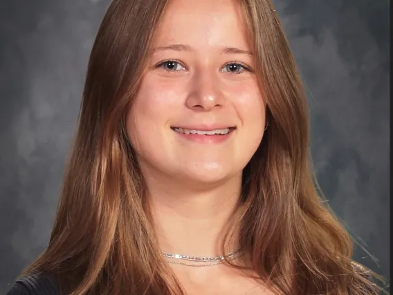 headshot of a person with a grey backdrop