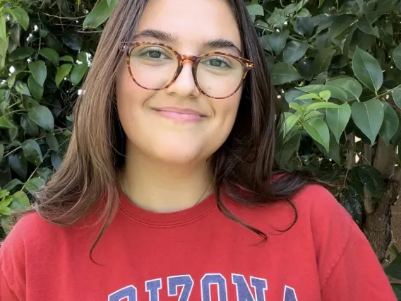 headshot of a person with trees in the background