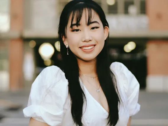 headshot of a person standing in front of a building