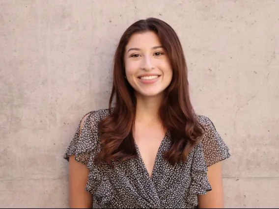 headshot of a person standing in front of a solid -colored background