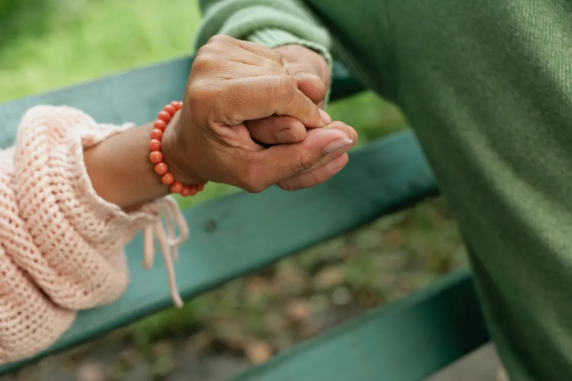 close-up of two hands holding on to one another