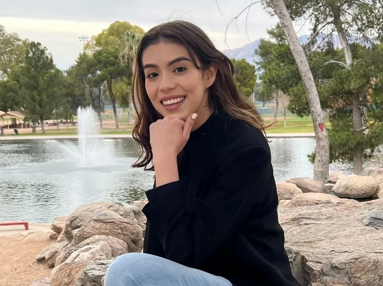 person sitting outdoors with a body of water visible in the background