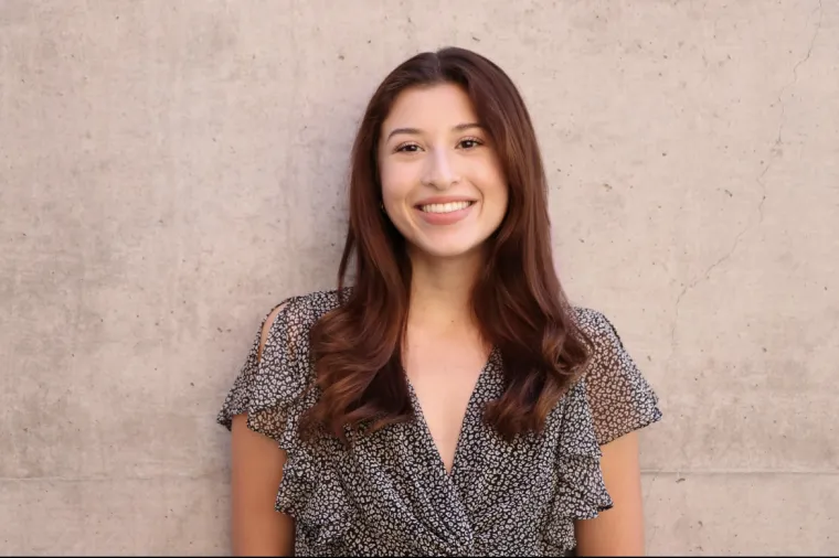 headshot of a person standing in front of a solid -colored background